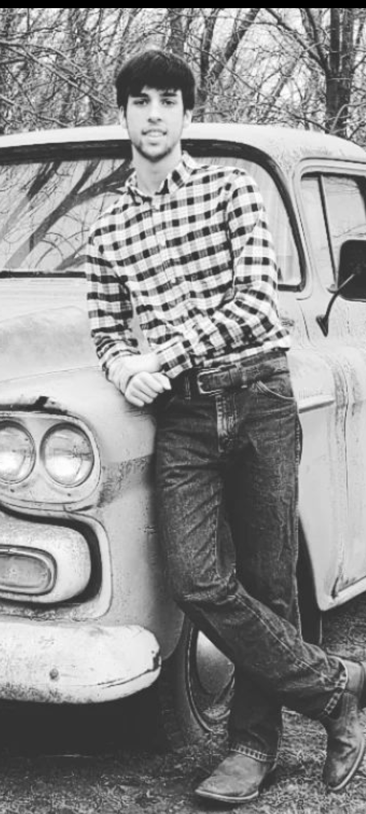 Logan leaning on a truck